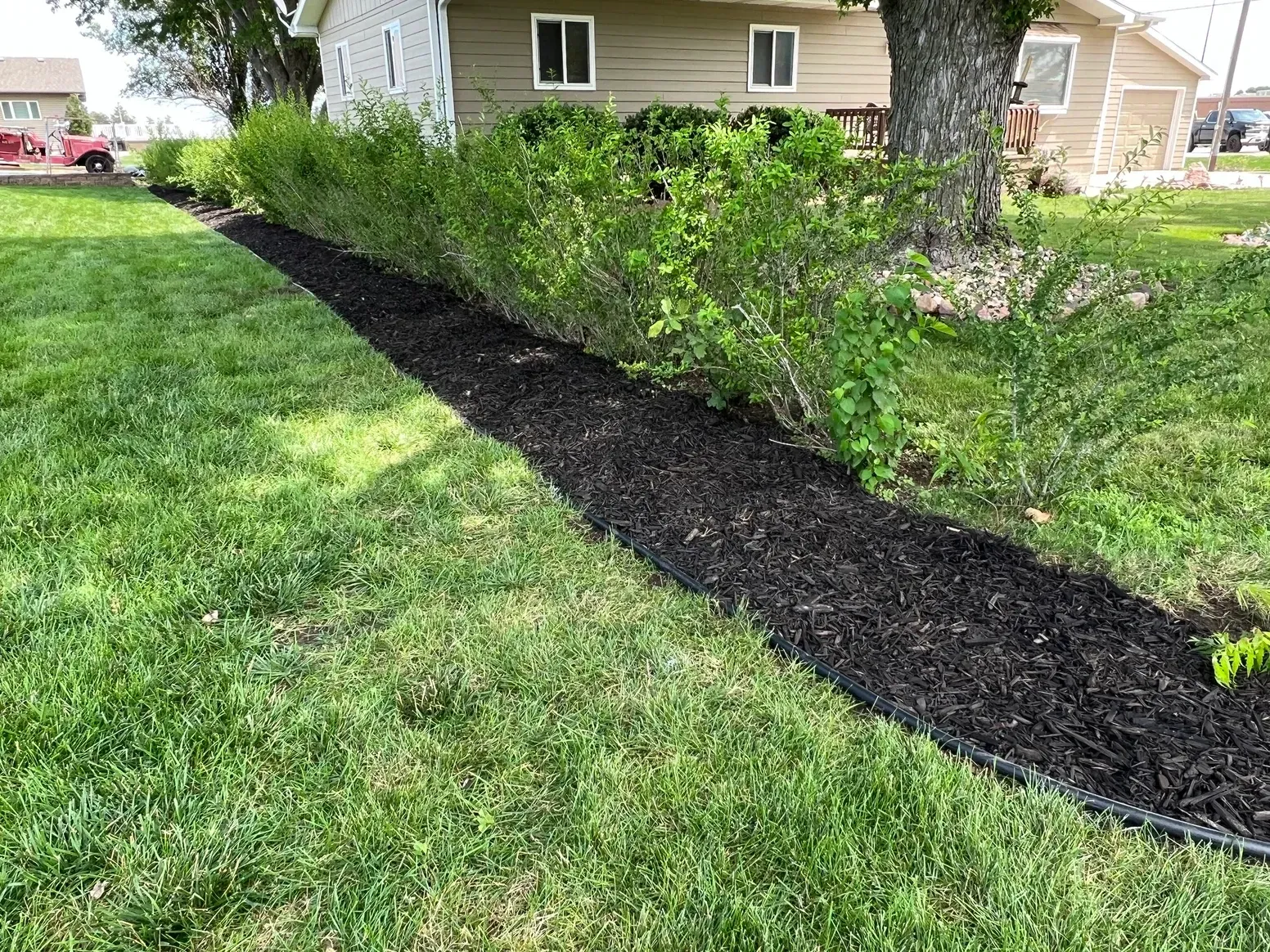 A Lush Green Lawn with A Path Leading to A House — Exeter, NE — Axline Landscaping & Trees