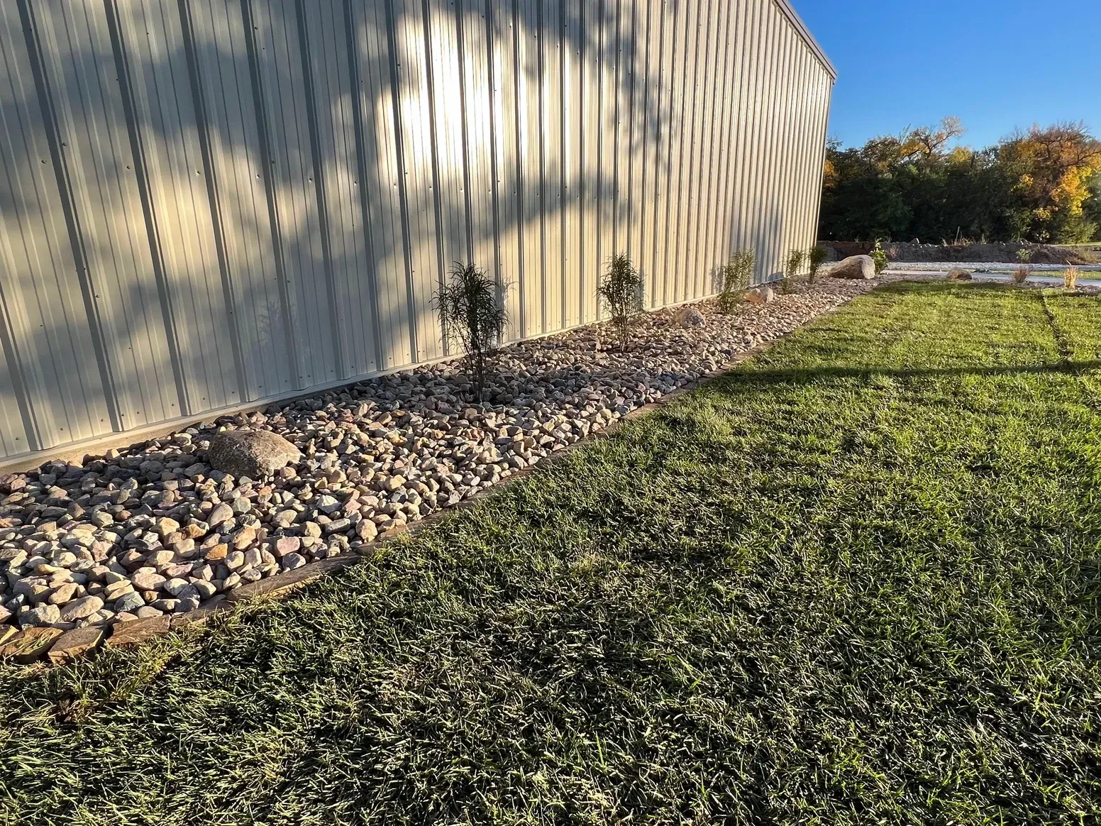 A Large Building with A Lot of Grass and Rocks — Exeter, NE — Axline Landscaping & Trees