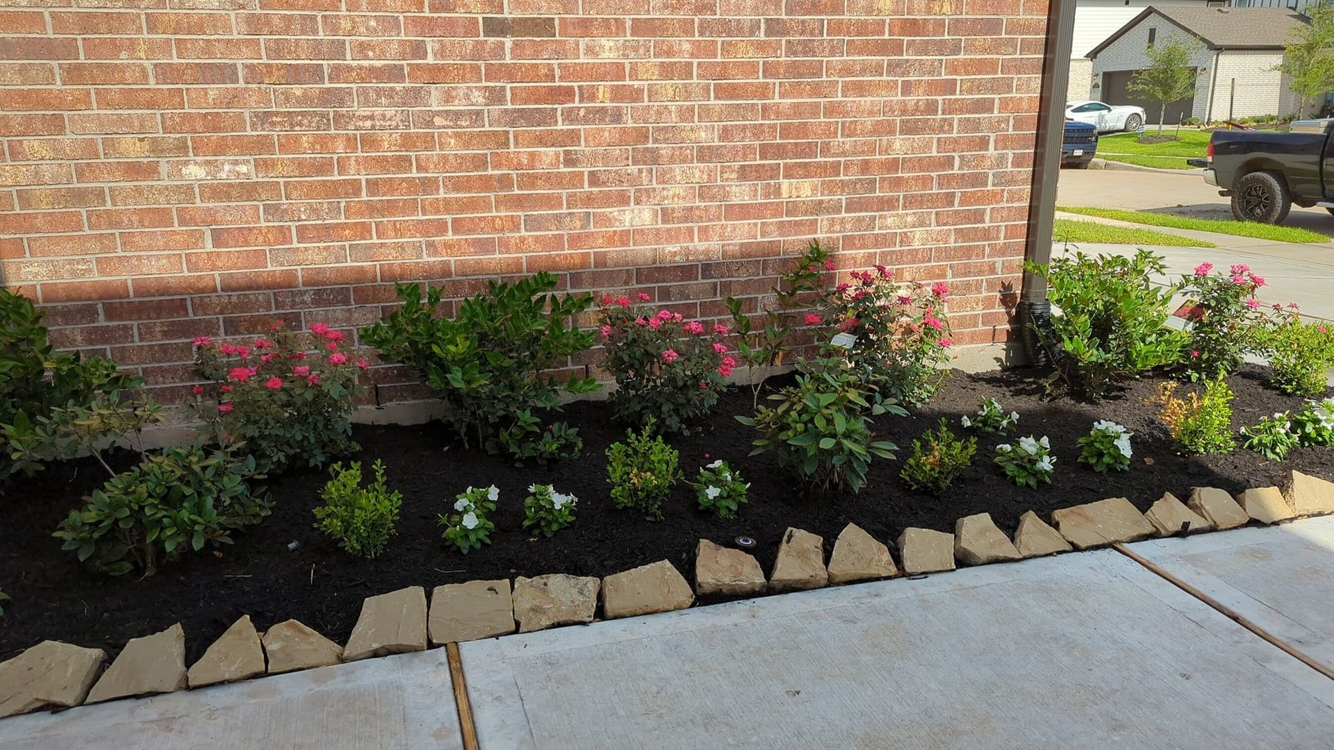 A brick wall with a garden in front of it