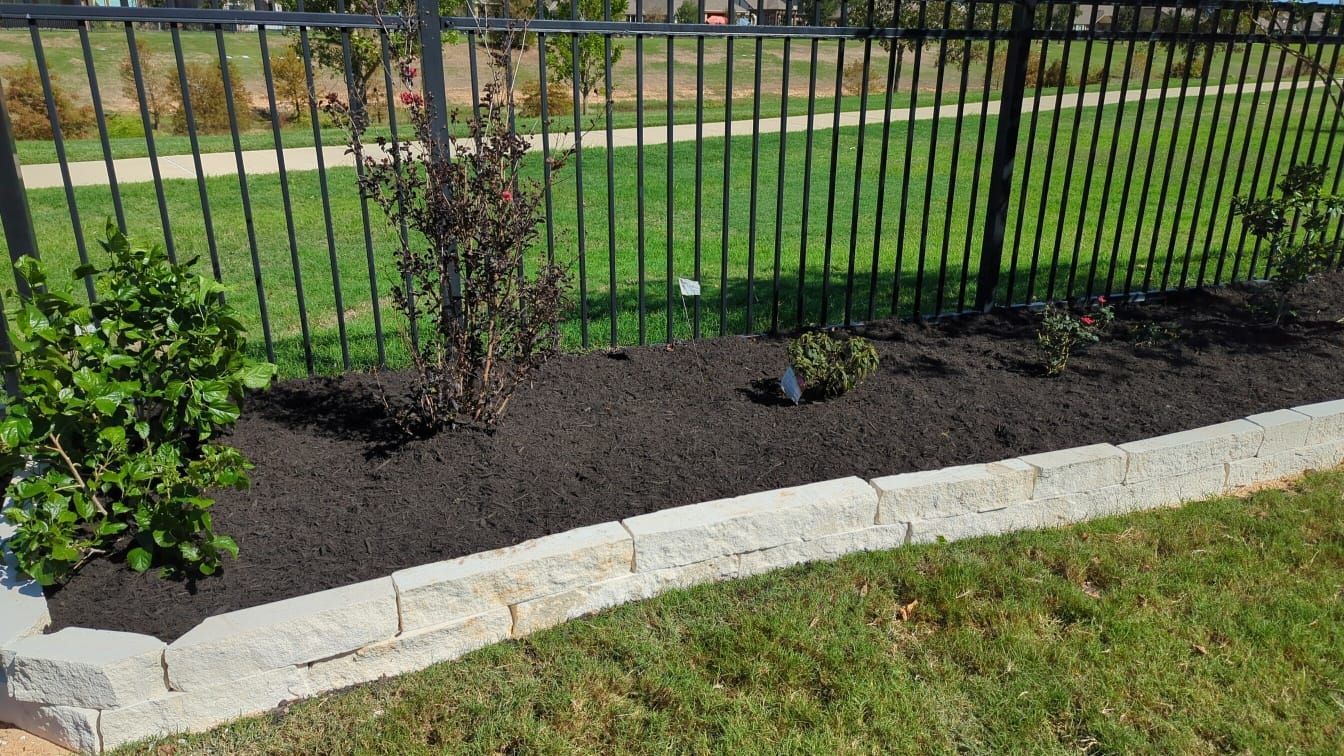 A black fence surrounds a lush green lawn.