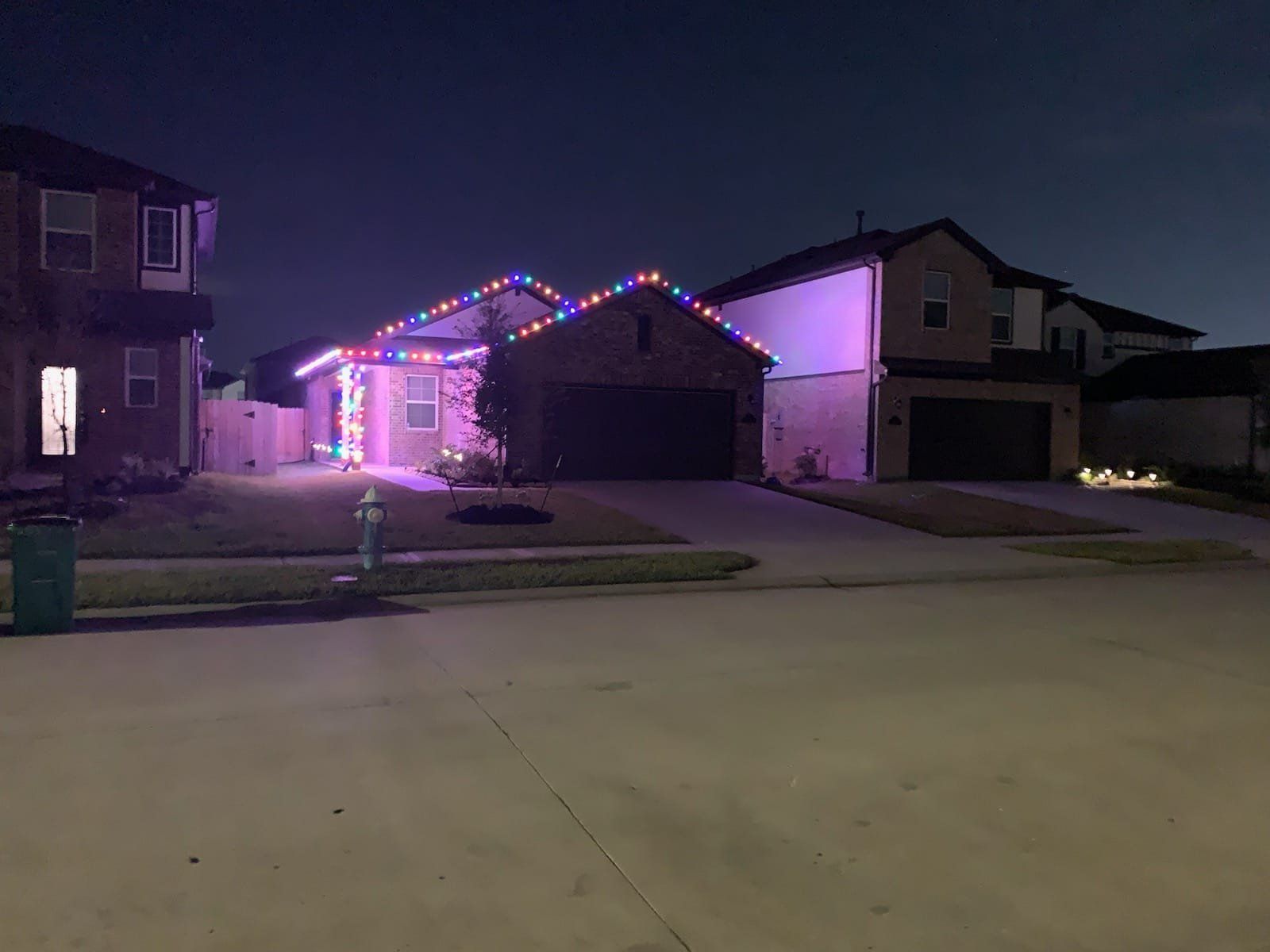 A house with christmas lights on it is lit up at night.
