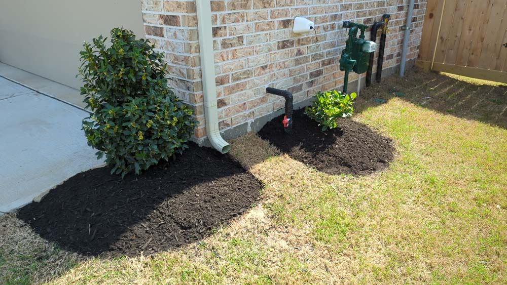 A brick house with a sprinkler on the side of it.