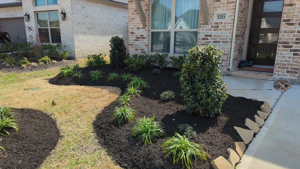 A brick house with a garden in front of it.