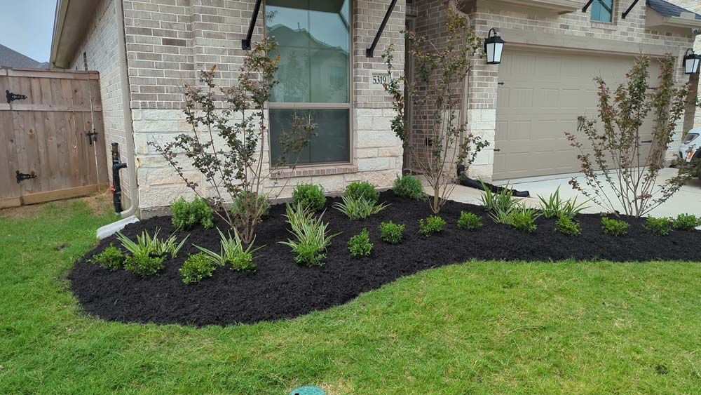 A brick house with a lush green lawn in front of it.