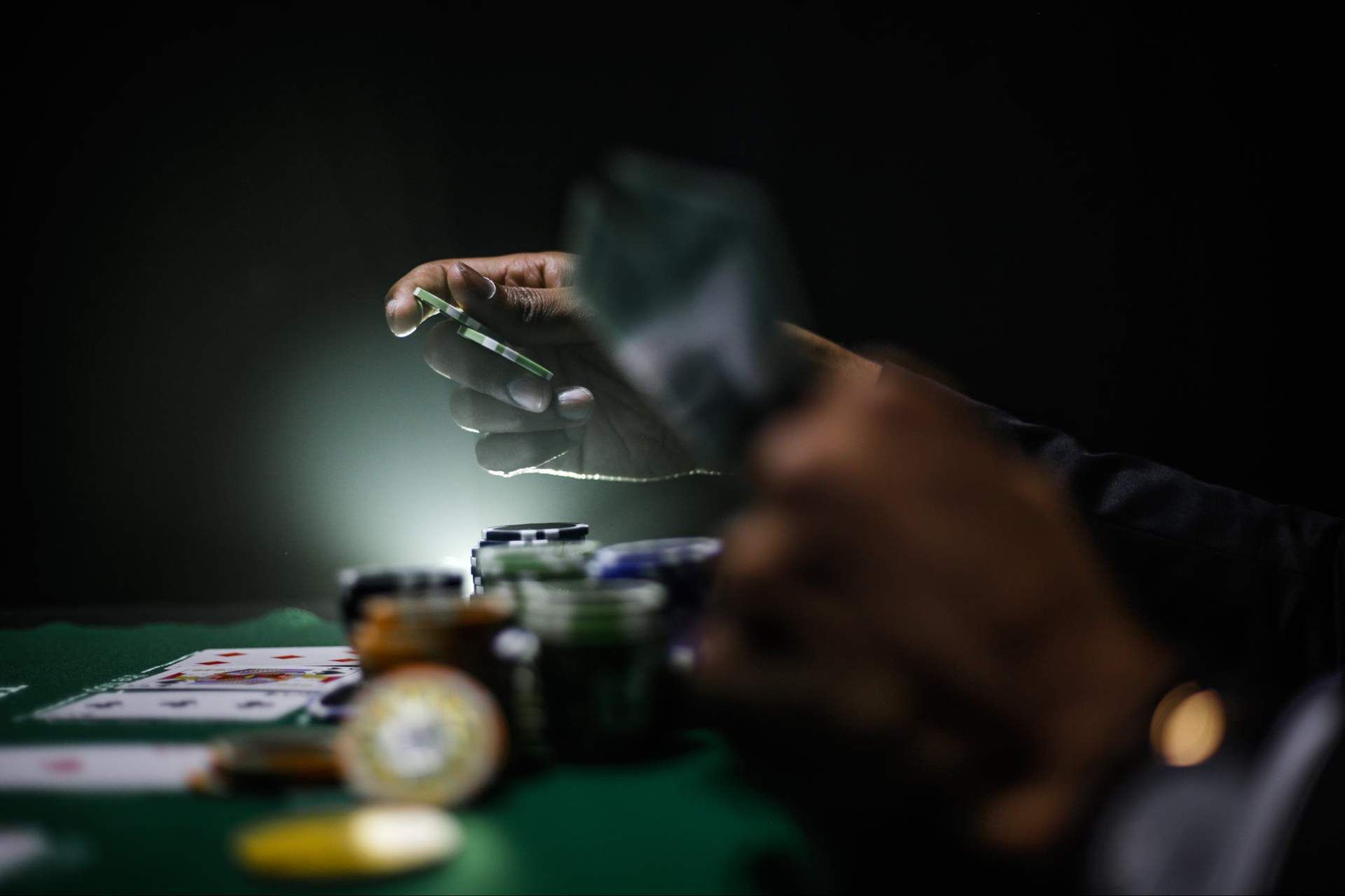a person is playing poker at a table with cards and chips .