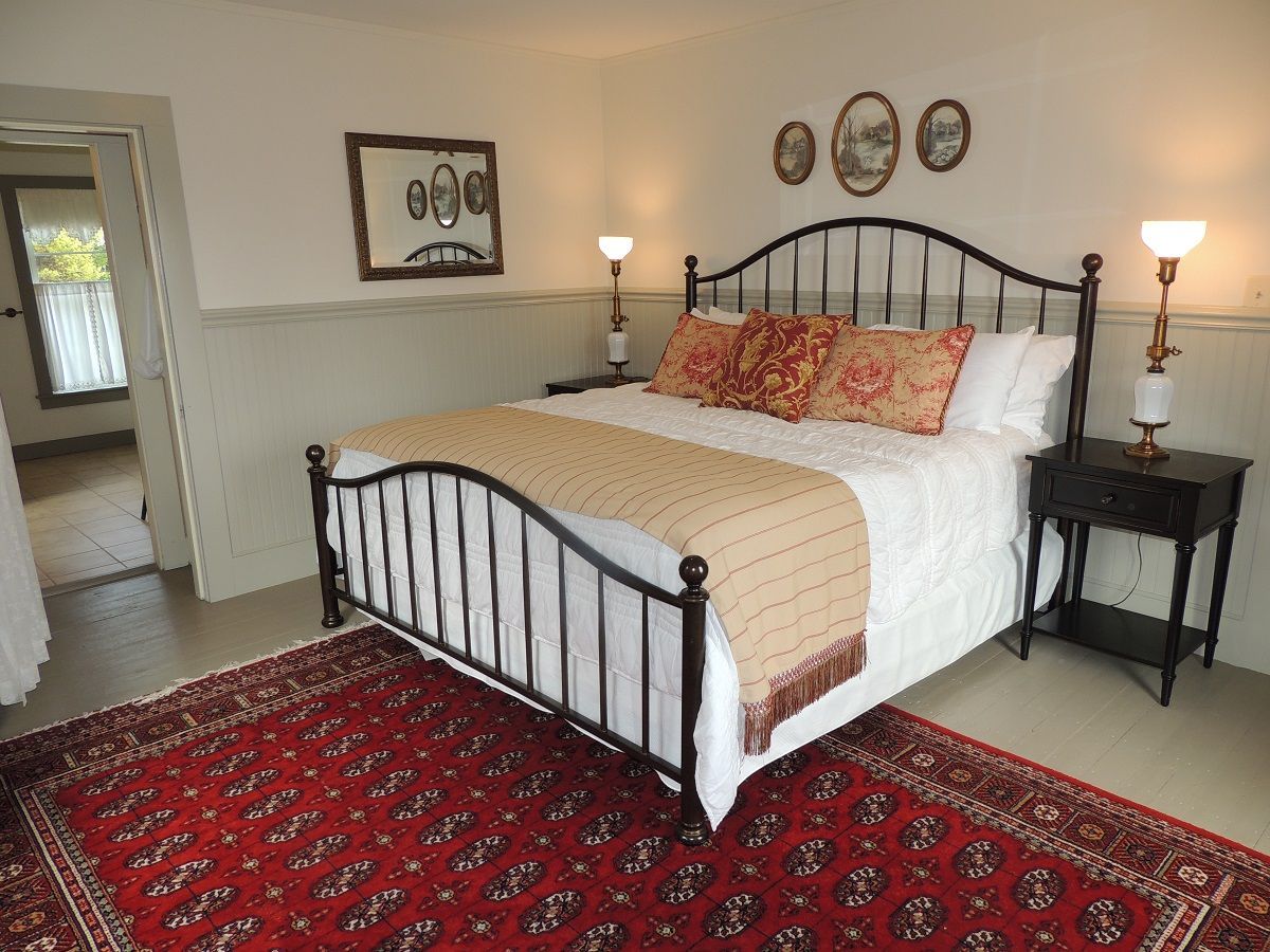 A bedroom with a large bed and a rug