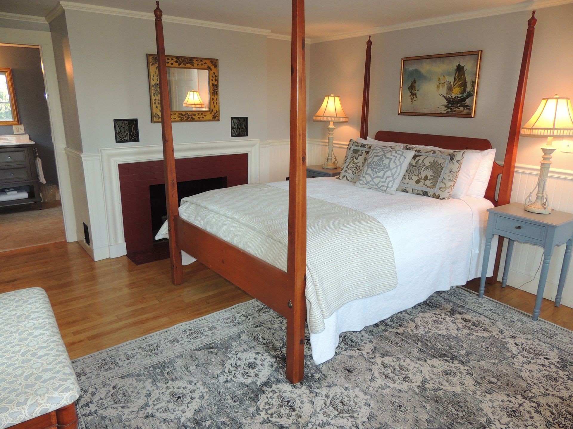 A bedroom with a four poster bed and a fireplace