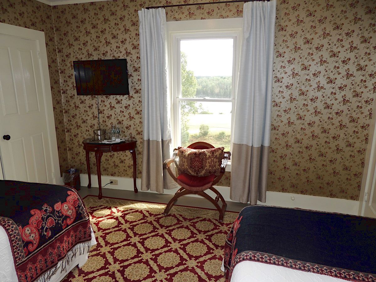A bedroom with two beds and a television on the wall