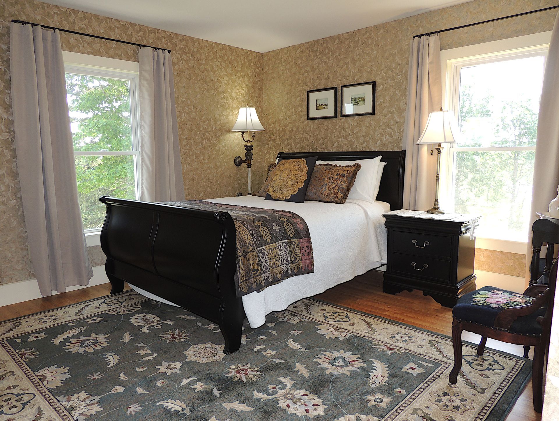 A bedroom with a sleigh bed and a rug
