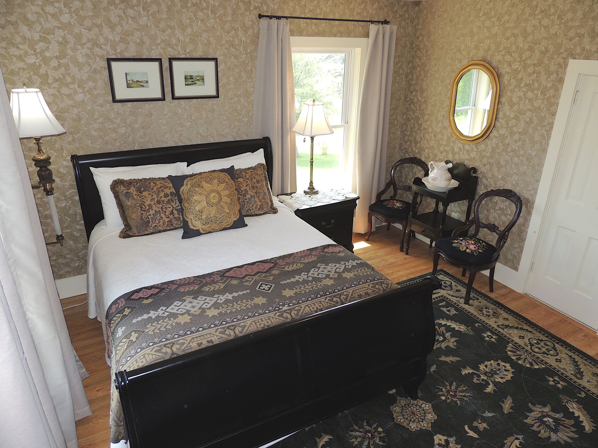 A bedroom with a king size bed and two chairs