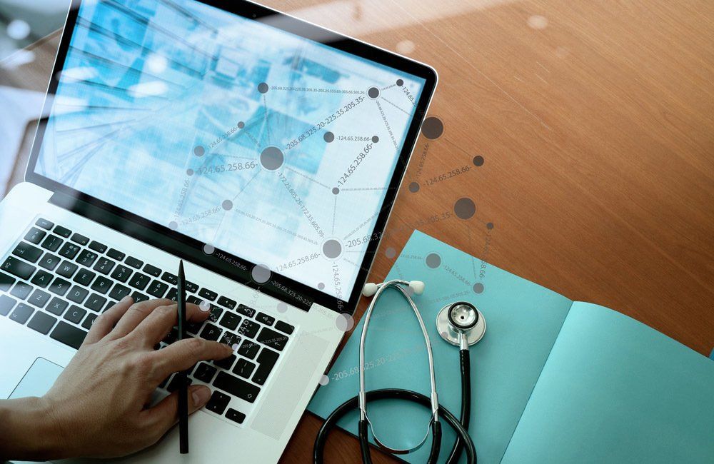 top view of Medicine doctor hand working with modern computer and smart phone with social media network on wooden desk as medical concept