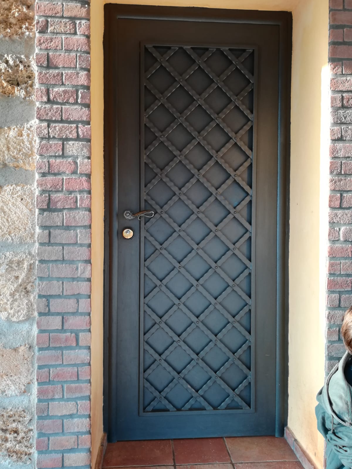 porta in ferro battuto con decorazioni a rete