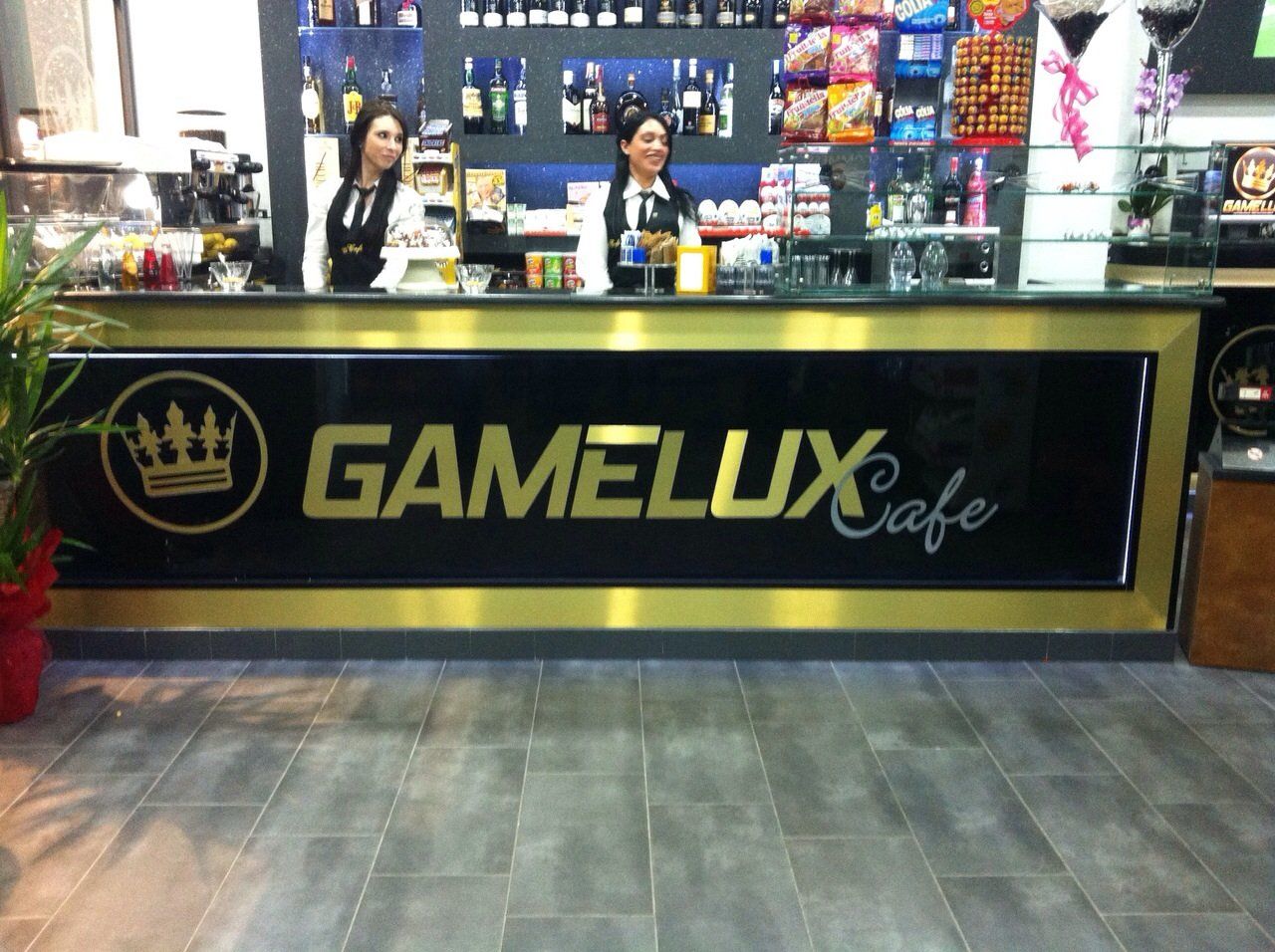 bancone bar con insegna dorata su sfondo nero