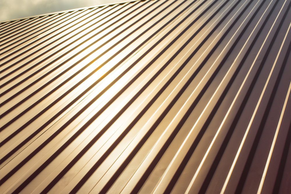 Brown metal roof with parallel ridges, catching sunlight — Coffs Coast Roofing In Sawtell, NSW