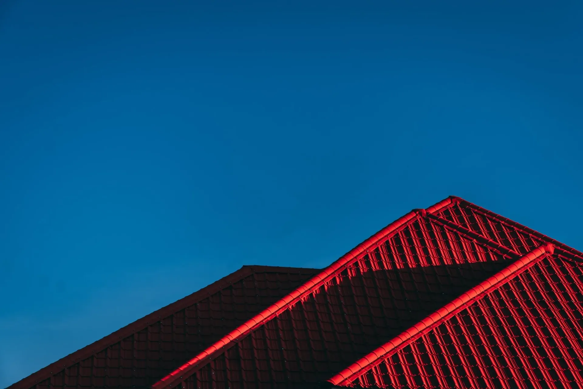 Red rooftop against a bright blue sky.
