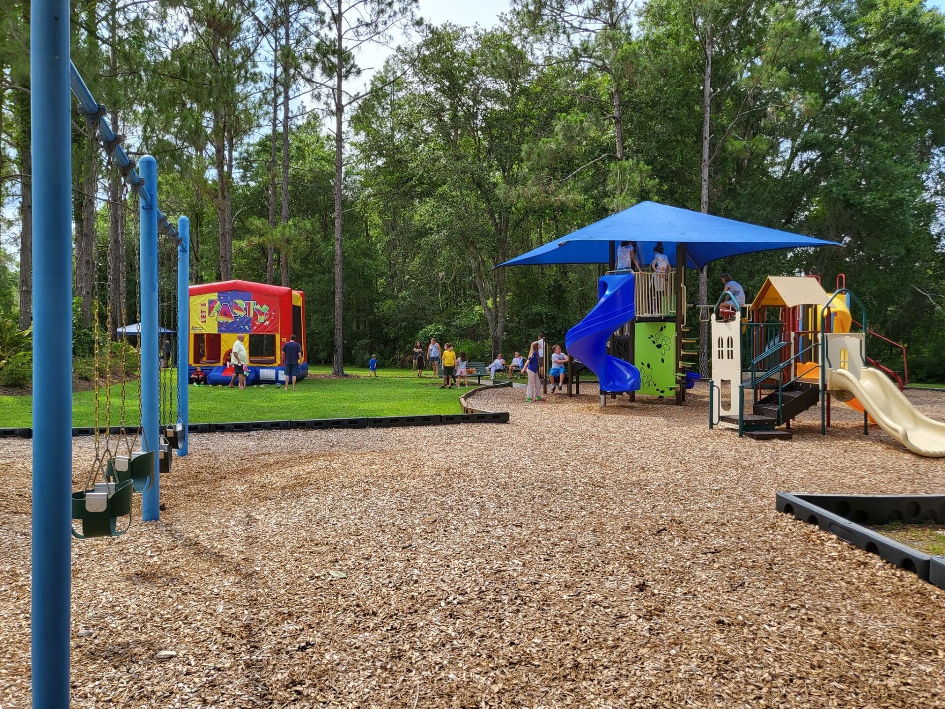 A playground with a bouncy house and a slide.