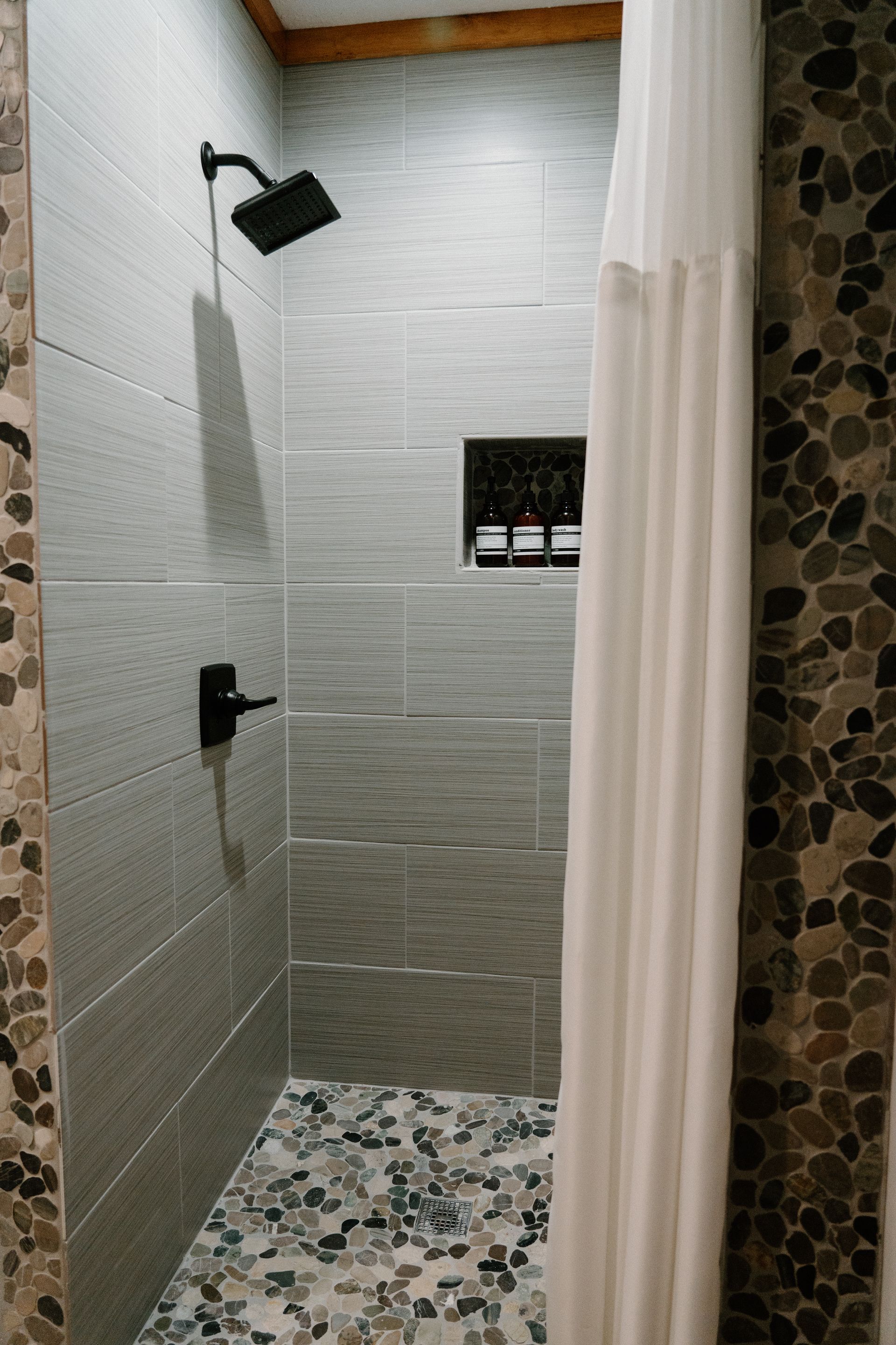 A bathroom with a walk in shower and a shower curtain.