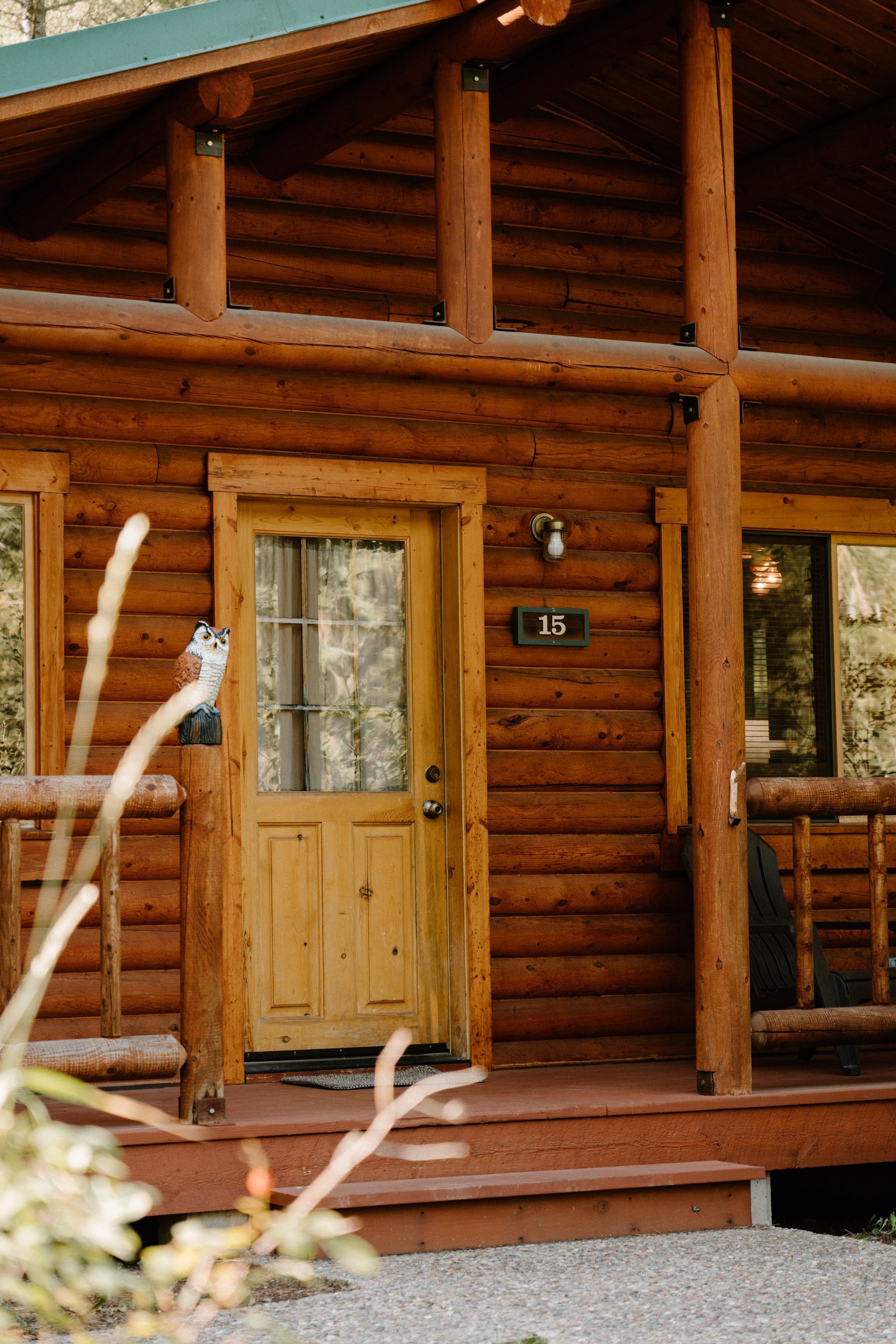 A log cabin with a porch and a yellow door.