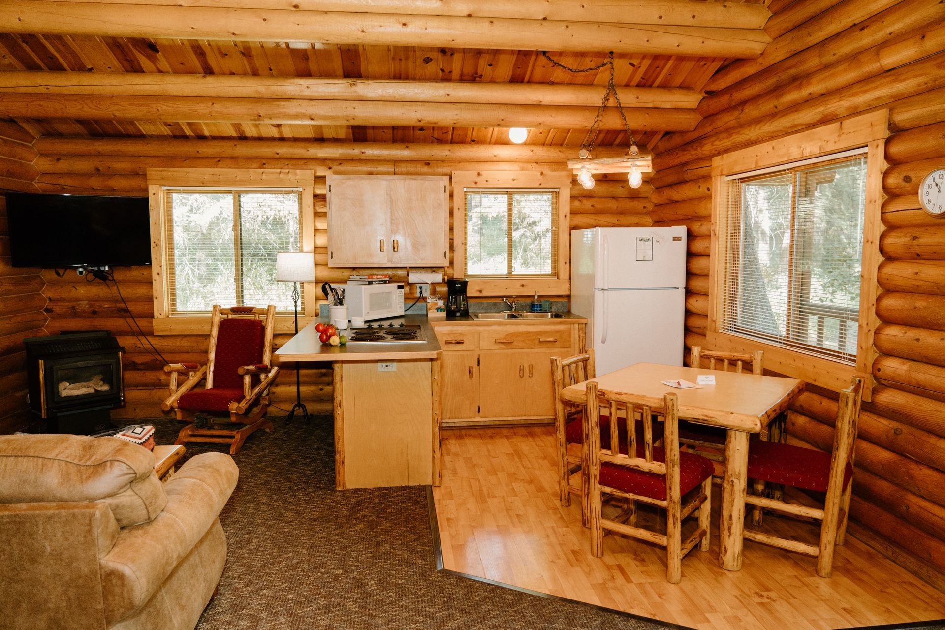 A log cabin with a kitchen , dining table and chairs.