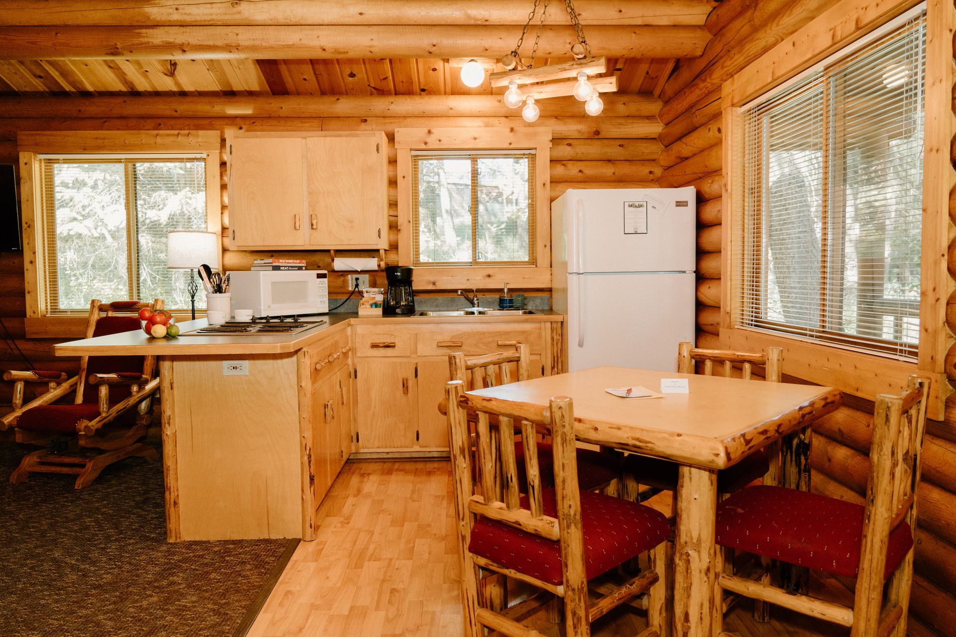 A kitchen in a log cabin with a table and chairs.