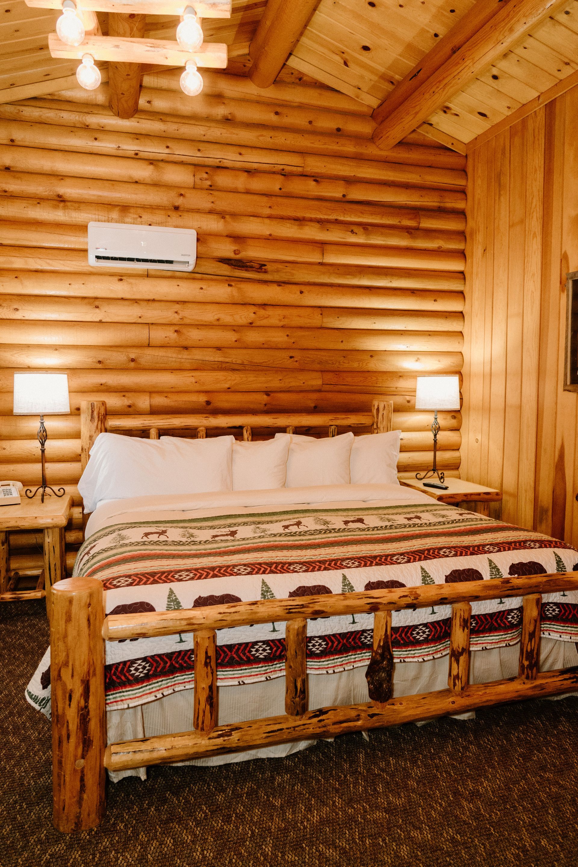 A bedroom in a log cabin with a king size bed.