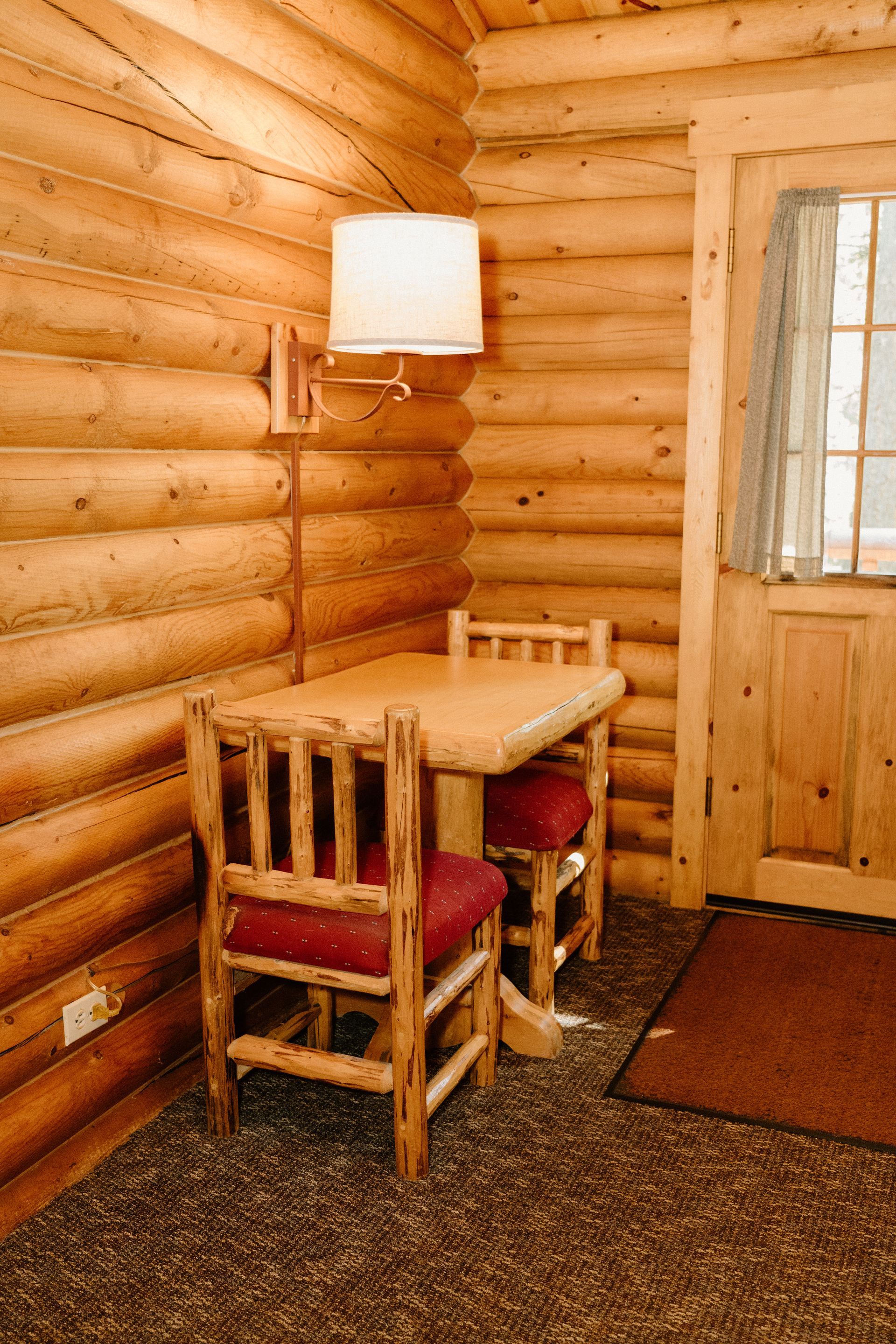 There is a table and chairs in a log cabin.