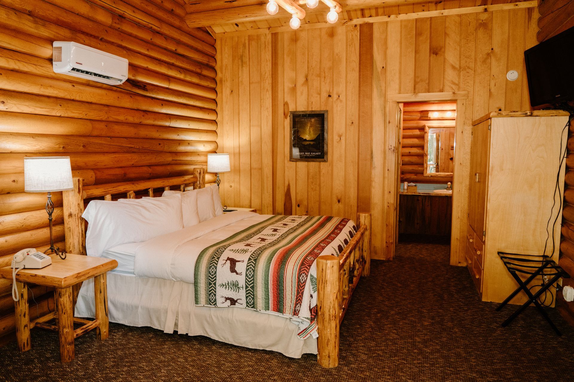 A bedroom in a log cabin with a king size bed.