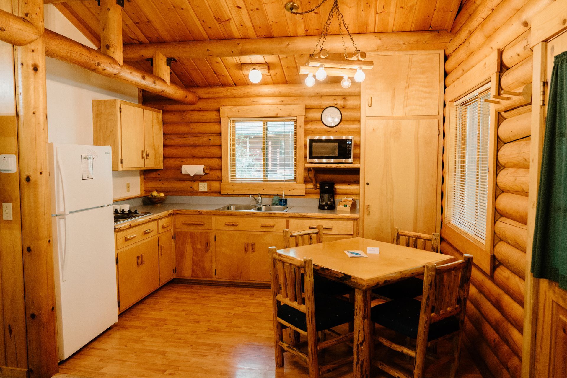 A kitchen in a log cabin with a table and chairs.