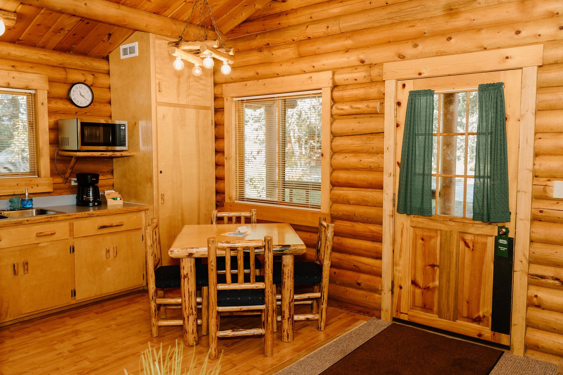 The inside of a log cabin with a table and chairs.