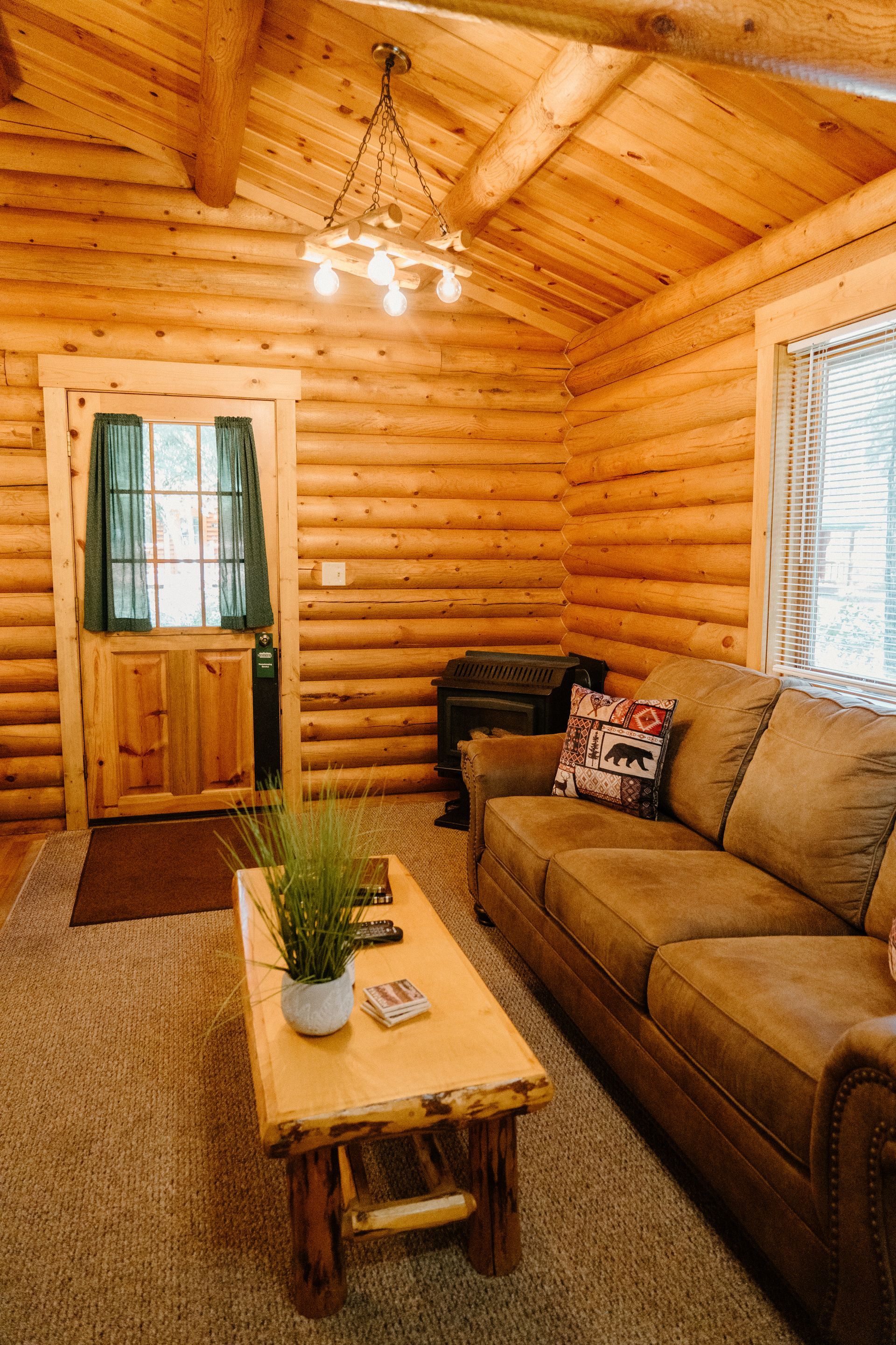 A living room in a log cabin with a couch and a coffee table.