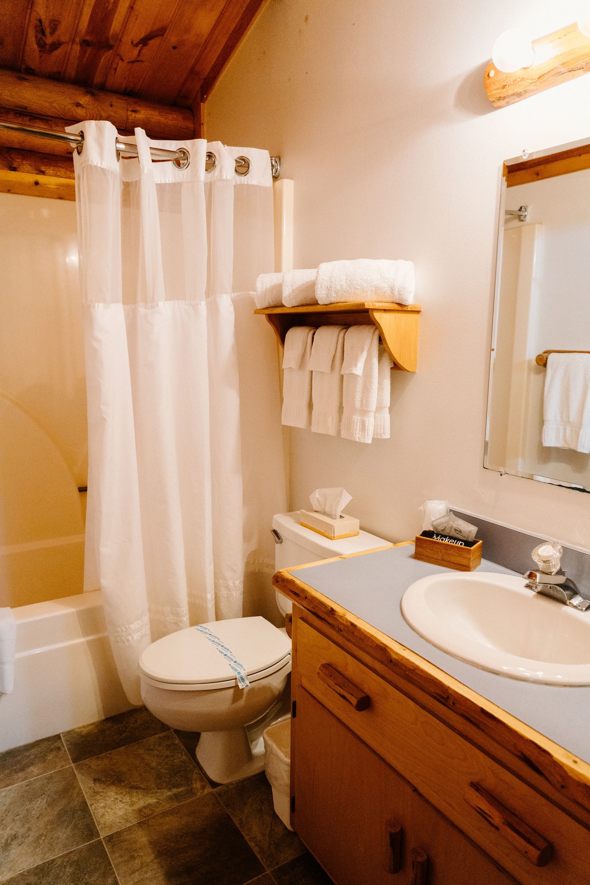 A bathroom with a toilet , sink , and shower curtain.