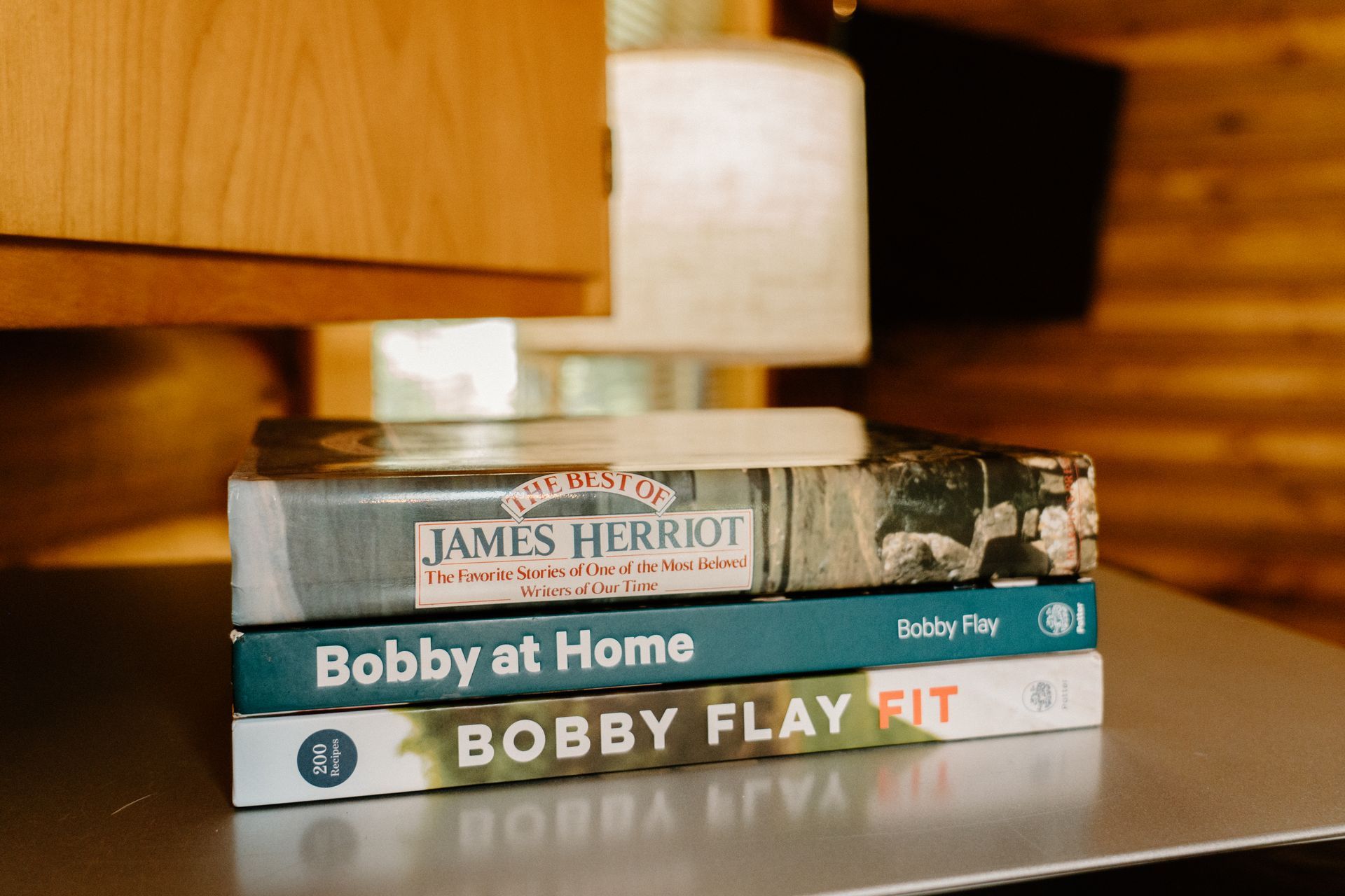 Three books are stacked on top of each other on a table.