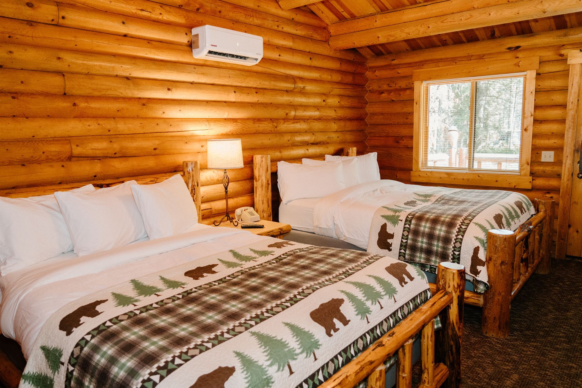 A log cabin with two beds and a window.