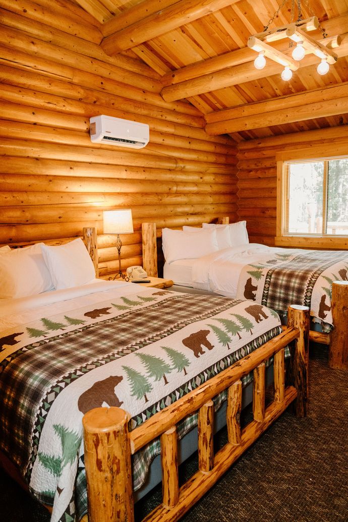 A log cabin with two beds and a window.