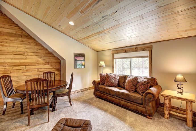 A living room with a couch , table and chairs