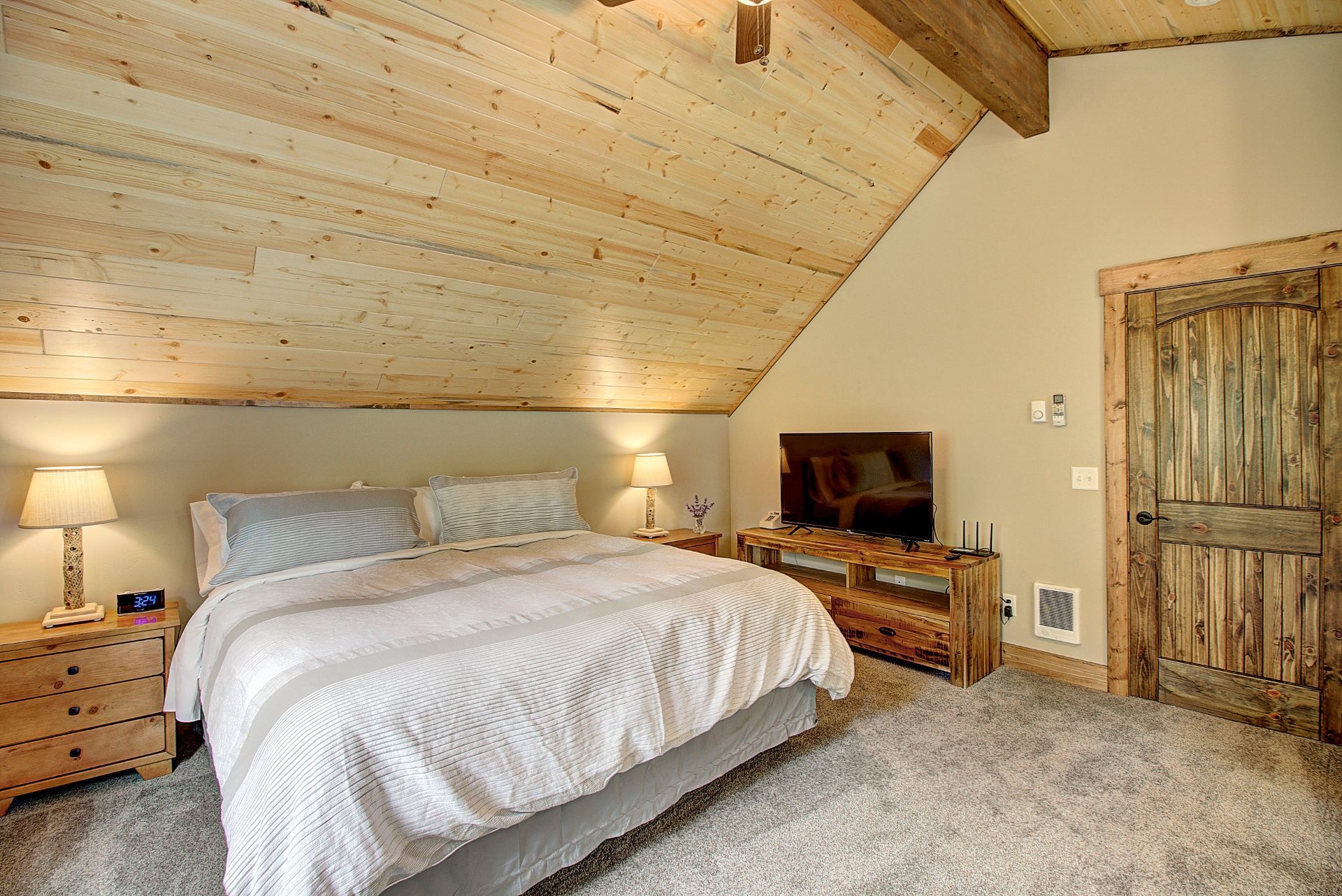 A bedroom with a king size bed and a flat screen tv.