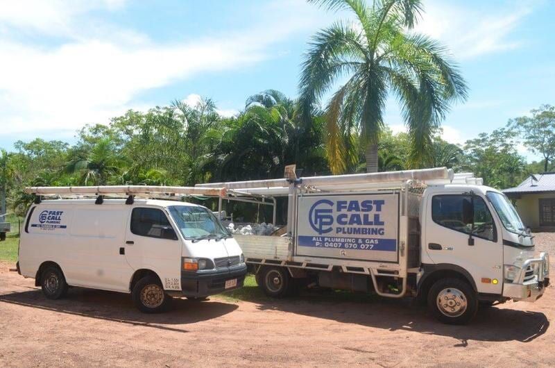 Two Fast Call Plumbing Trucks Are Parked Next to Each Other on a Dirt Road — Fastcall Group In Herbert, NT