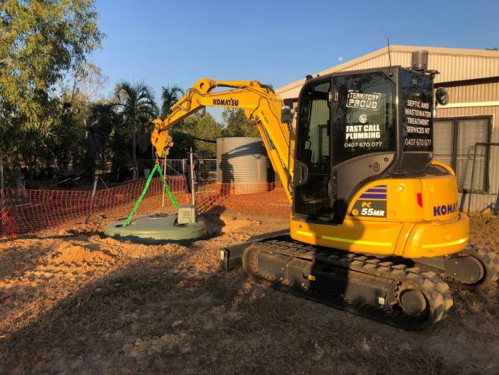A Yellow Excavator is Being Used to Lift a Septic Tank — Fastcall Group In Herbert, NT