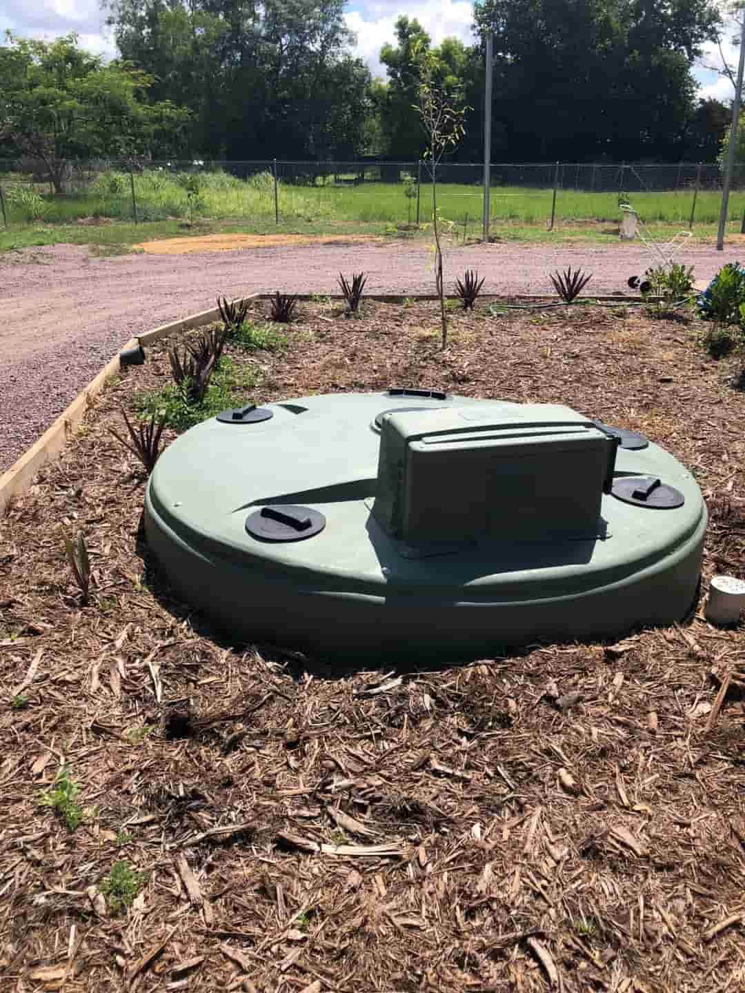 A Green Septic Tank is Sitting in the Middle of a Pile of Mulch — Fastcall Group In Herbert, NT