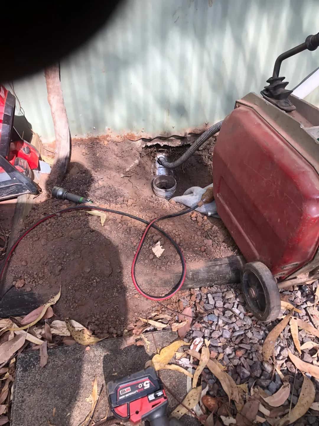 A Red Suitcase is Sitting on the Ground Next to a Drill — Fastcall Group In Herbert, NT