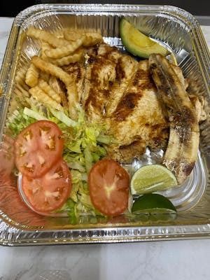 A foil container filled with chicken , french fries , tomatoes , lettuce and avocado.