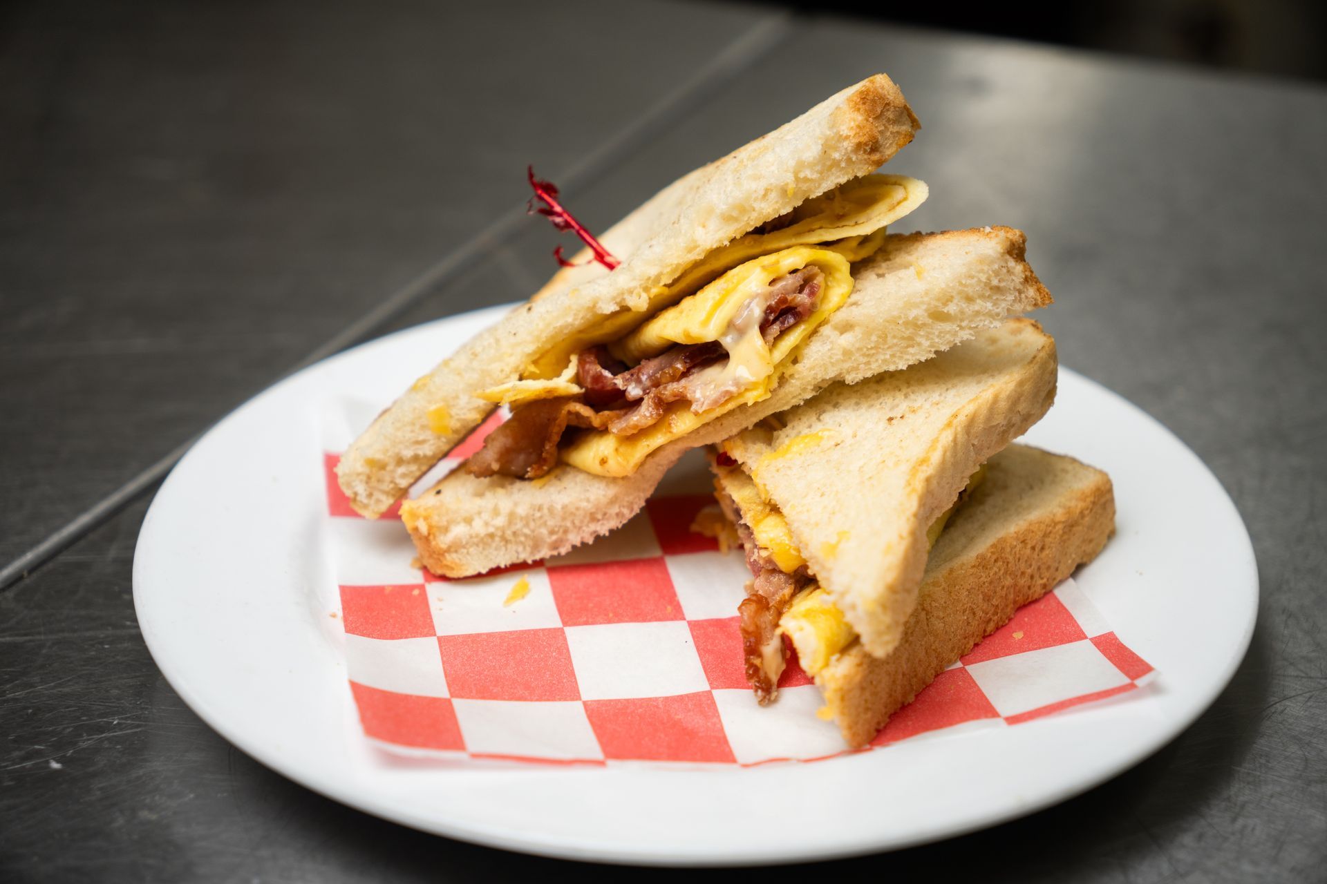 A person is holding a plate of food with eggs and sauce.