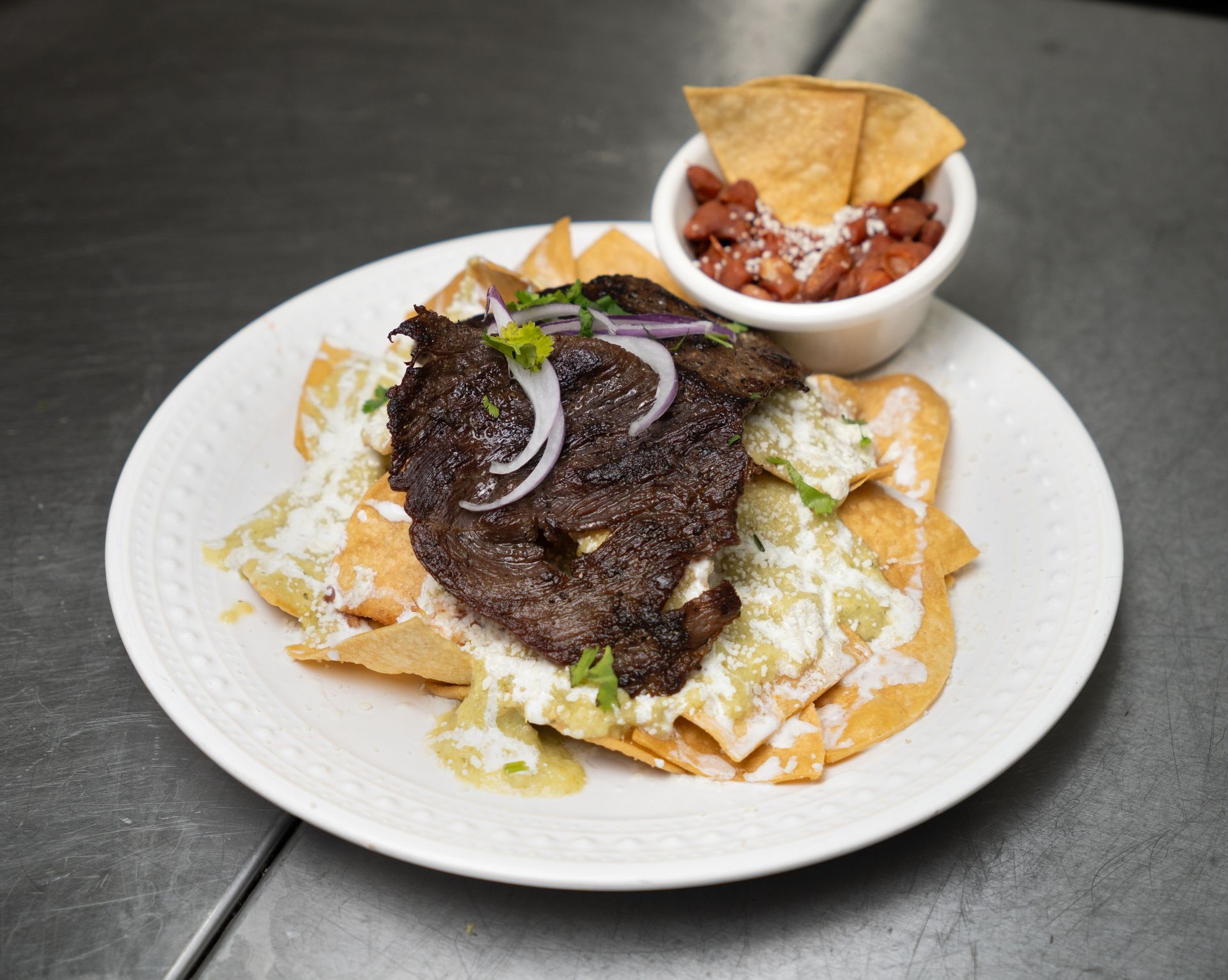 A plate of food is sitting in front of a painting on a wall.