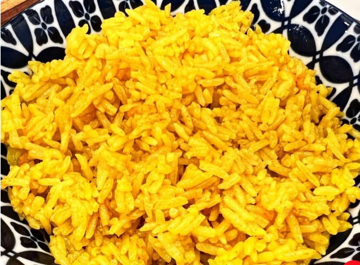 A person is holding a plate of food with eggs and sauce.