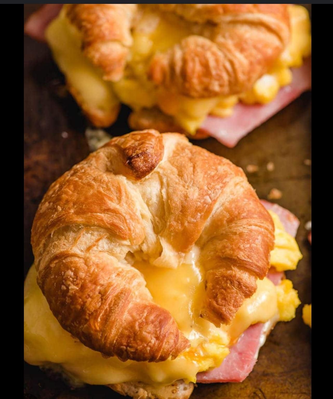 A person is holding a plate of food with eggs and sauce.
