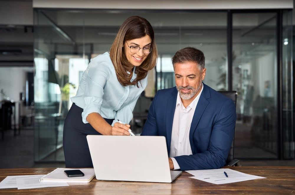 Un hombre y una mujer están mirando una computadora portátil.