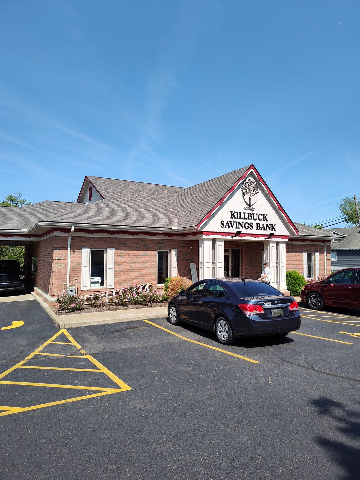 A car is parked in front of a brick building.