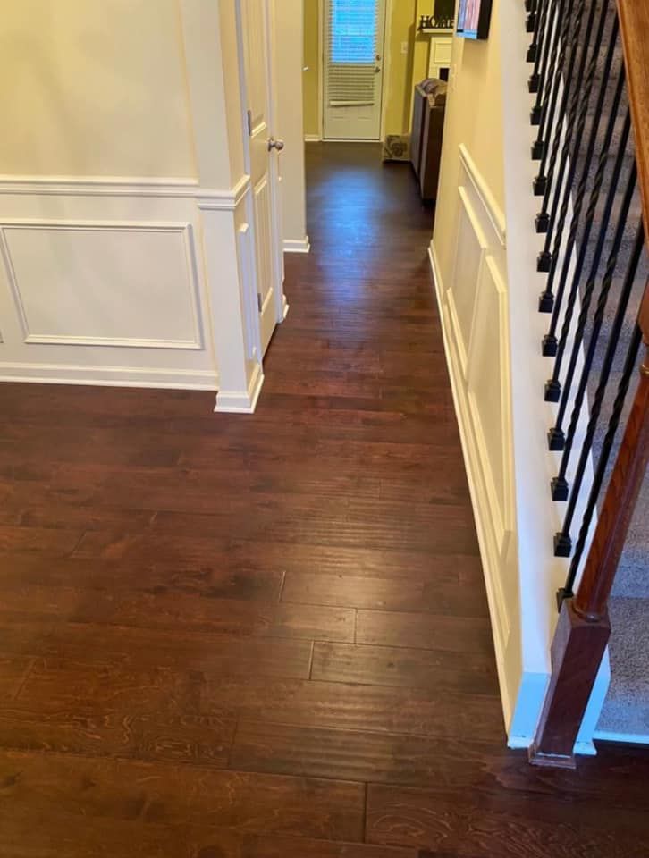 A hallway with hardwood floors and stairs in a house.