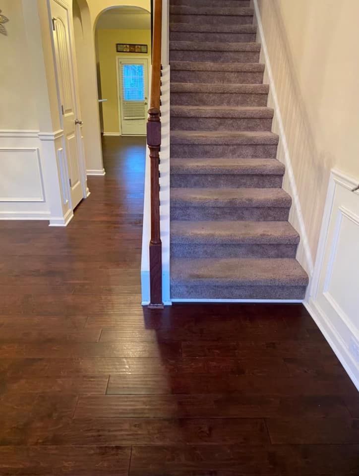 A staircase with carpeted steps leading up to the second floor of a house.