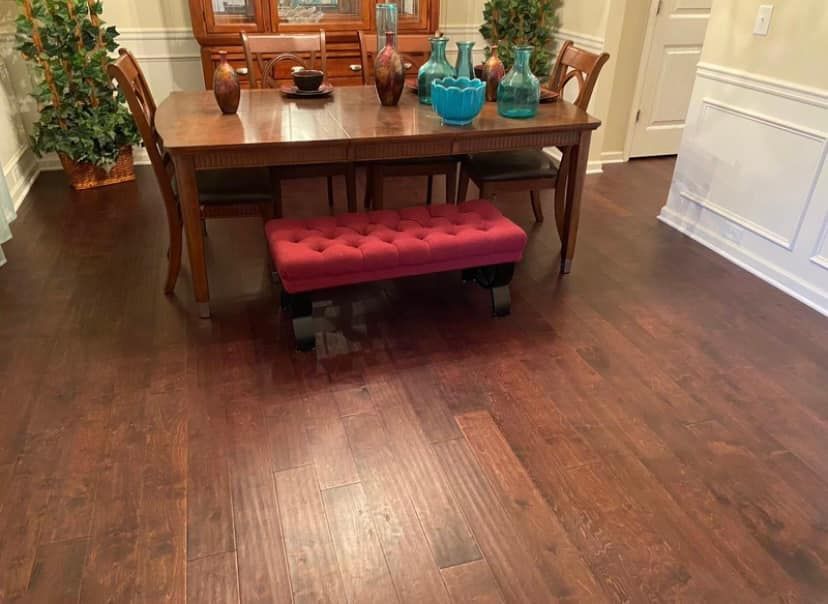 A dining room with a wooden table and chairs and a red bench.